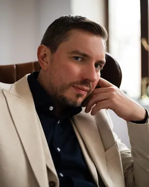 Lex Tarrel, создатель системы CoreTypes, в светлом пиджаке и темной рубашке сидит в кожаном кресле, рука у щеки
